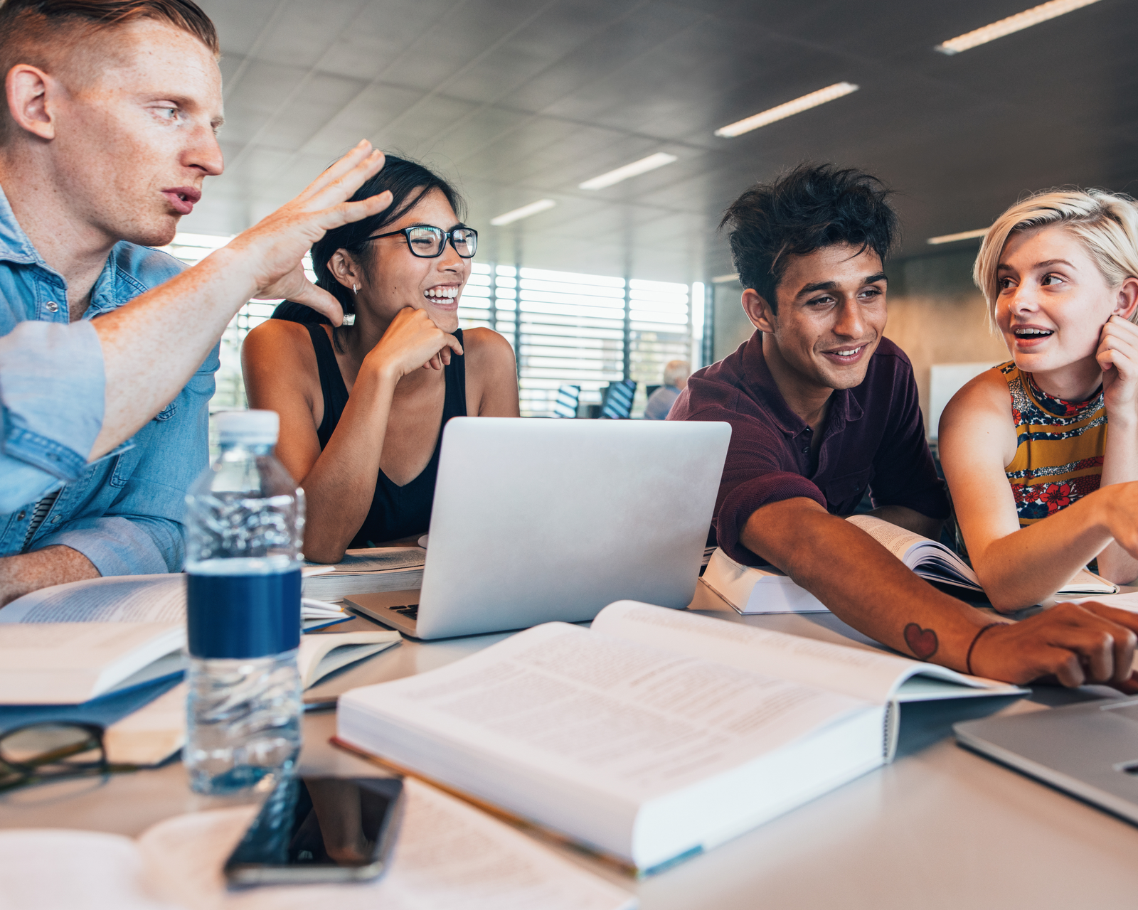 Educators collaborating around a table with laptops